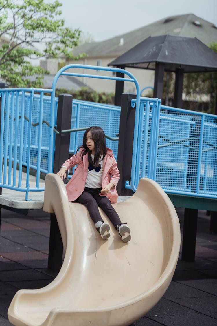 A Girl Sitting On A Slide