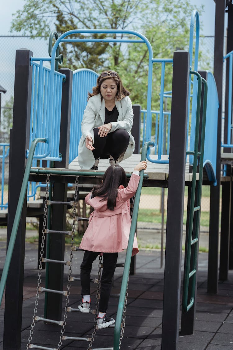 Mother And Daughter On A Playground 