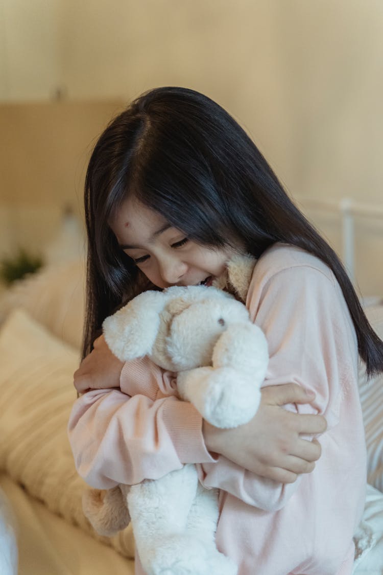 A Girl Cuddling A Doll