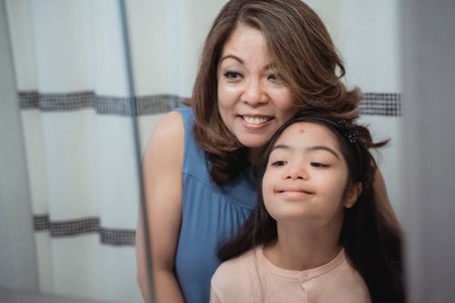 Free A joyful mom and daughter gaze together at their reflection, sharing a tender moment. Stock Photo