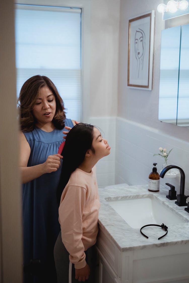 Woman Brushing Child Hair