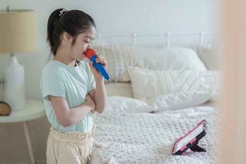 Foto profissional grátis de bonita, cama, cantando