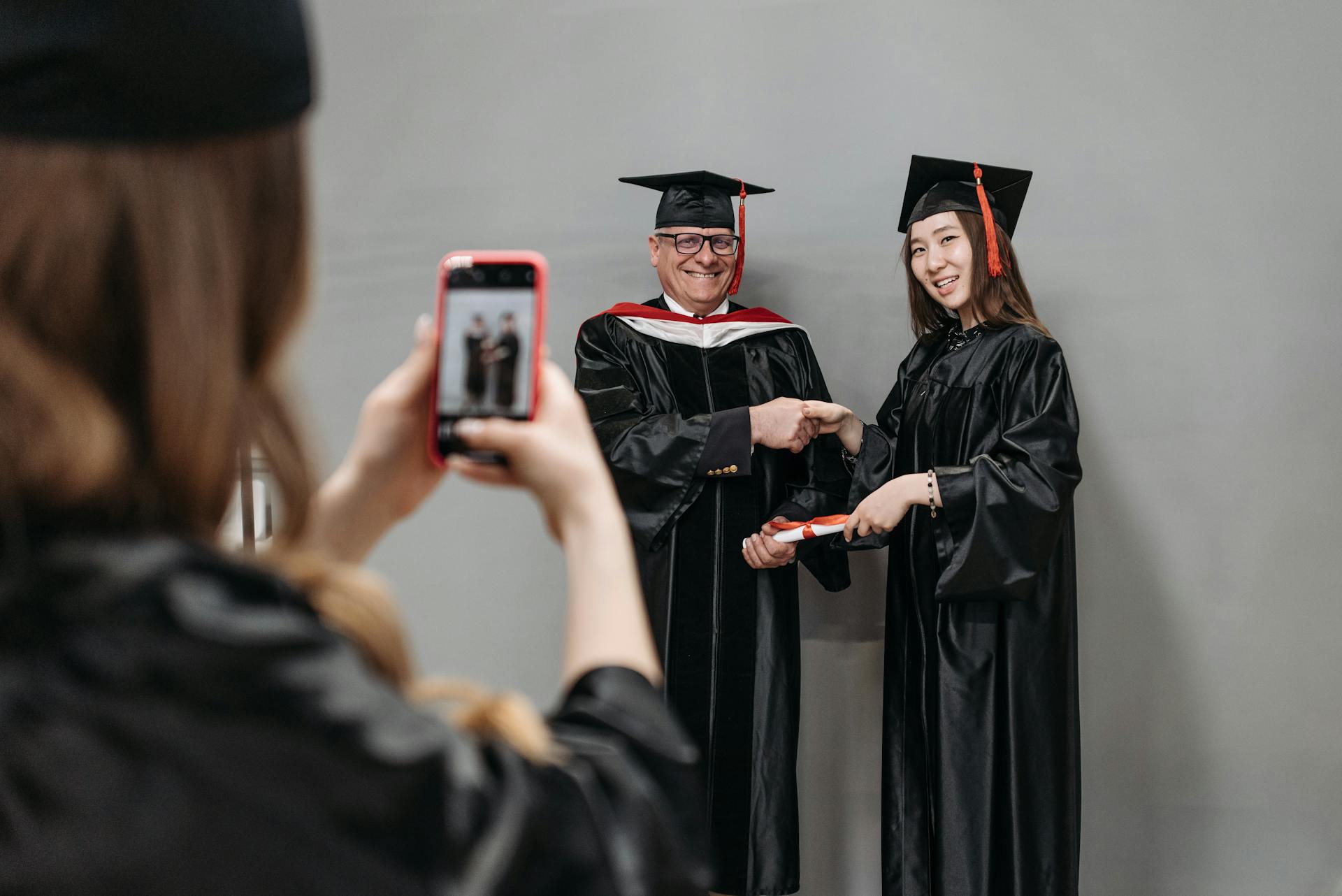 Photo of Woman in Black Academic Gown Receiving Gown