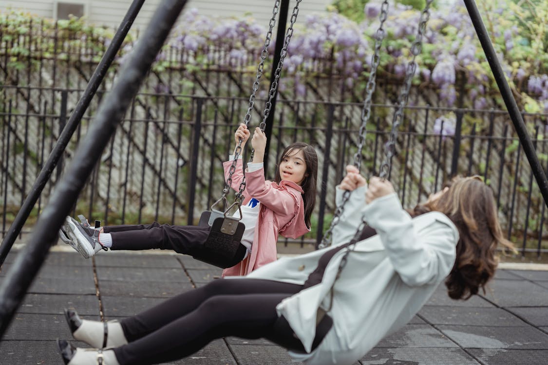 Free A Woman and a Young Girl Playing on the Swing Stock Photo
