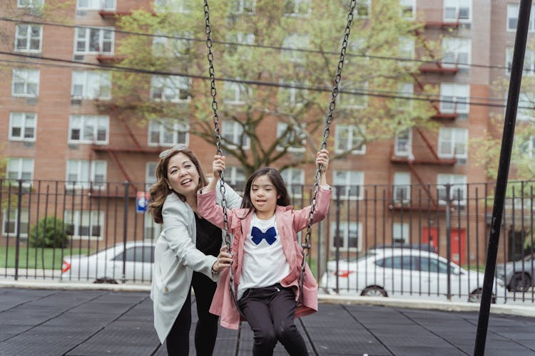 Mother And Daughter Playing On A Playground