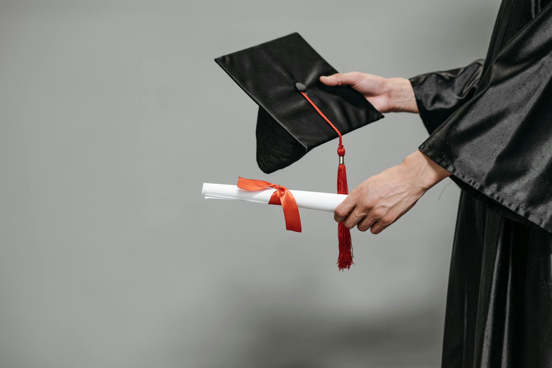 Photo of Person Holding Graduation Cap and Diploma