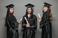 Photo of Women in Black Academic Dress Holding Diploma