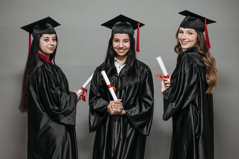 Graduates in caps and gowns with diplomas