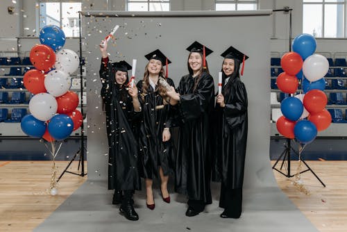 Photo of Happy Women in Black Academic Dress