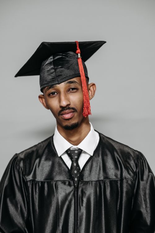 Free Proud young graduate wearing a black gown and cap with tassel Stock Photo