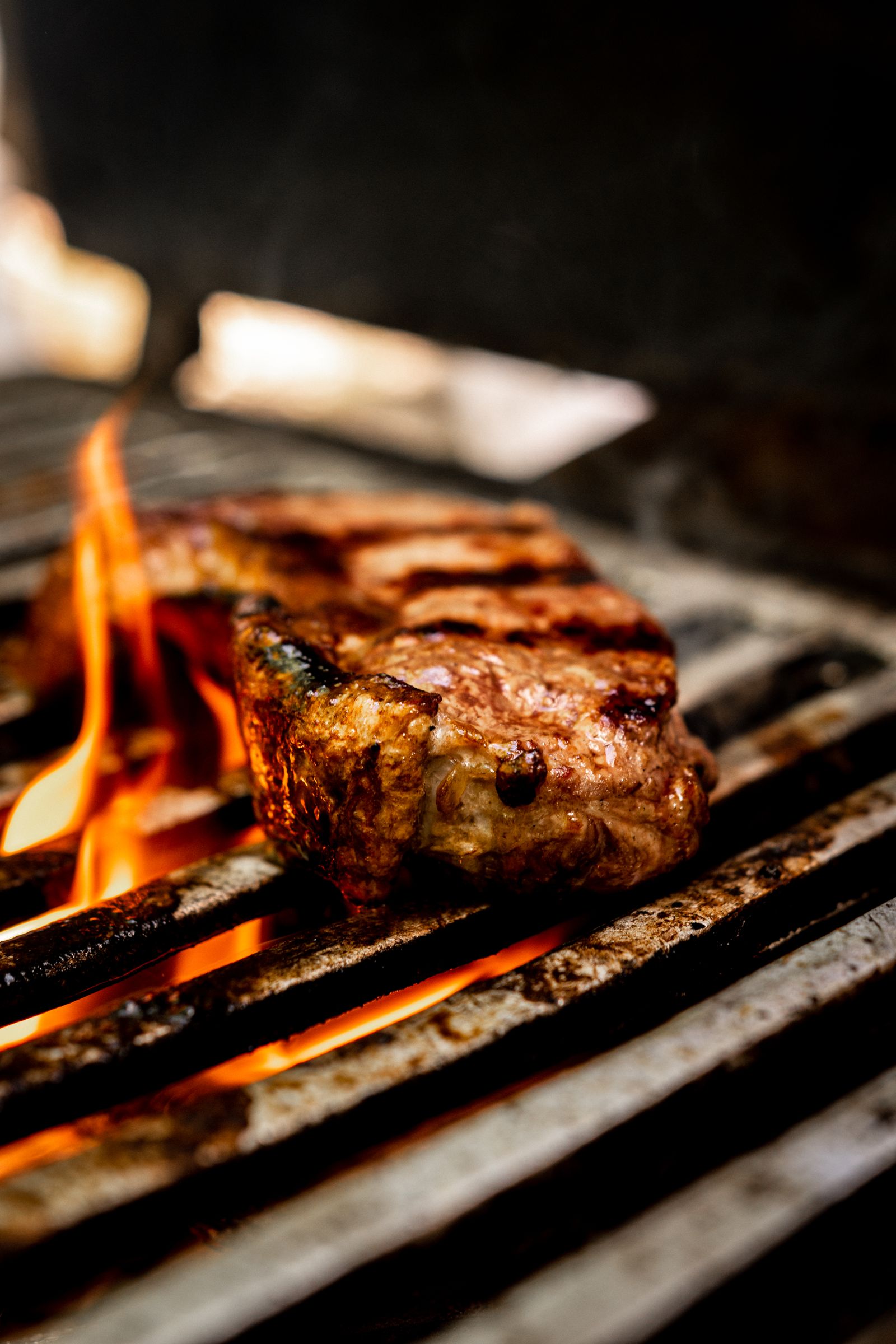 A steak sizzling over open flames on a grill