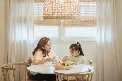 Free A Woman Eating Breakfast with Her Daughter Stock Photo