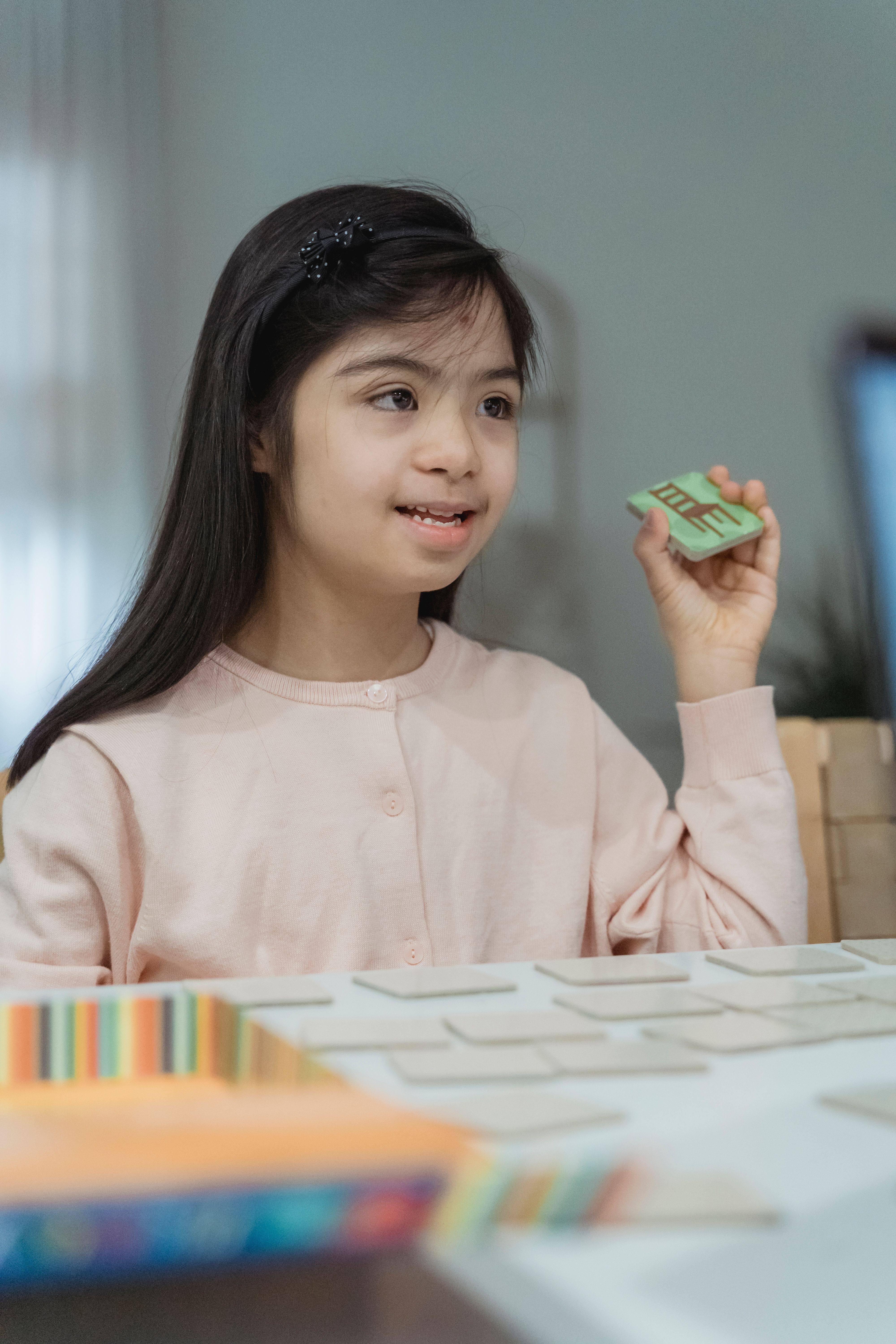 A child at a table using colorful educational cards during a focused early learning activity