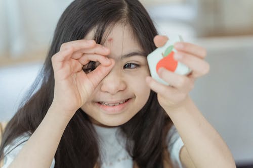 Free A Young Girl Smiling with Her Hand on Her Face Stock Photo
