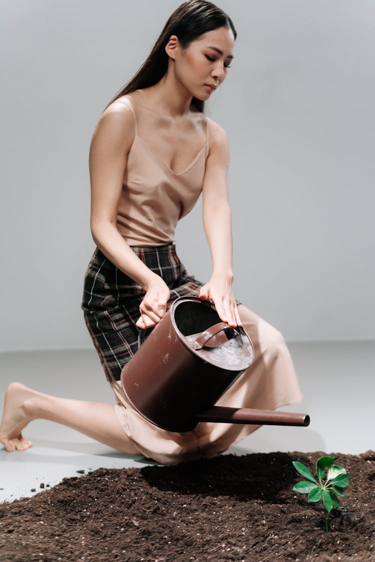 Studio Shoot Of A Woman Watering A Plant