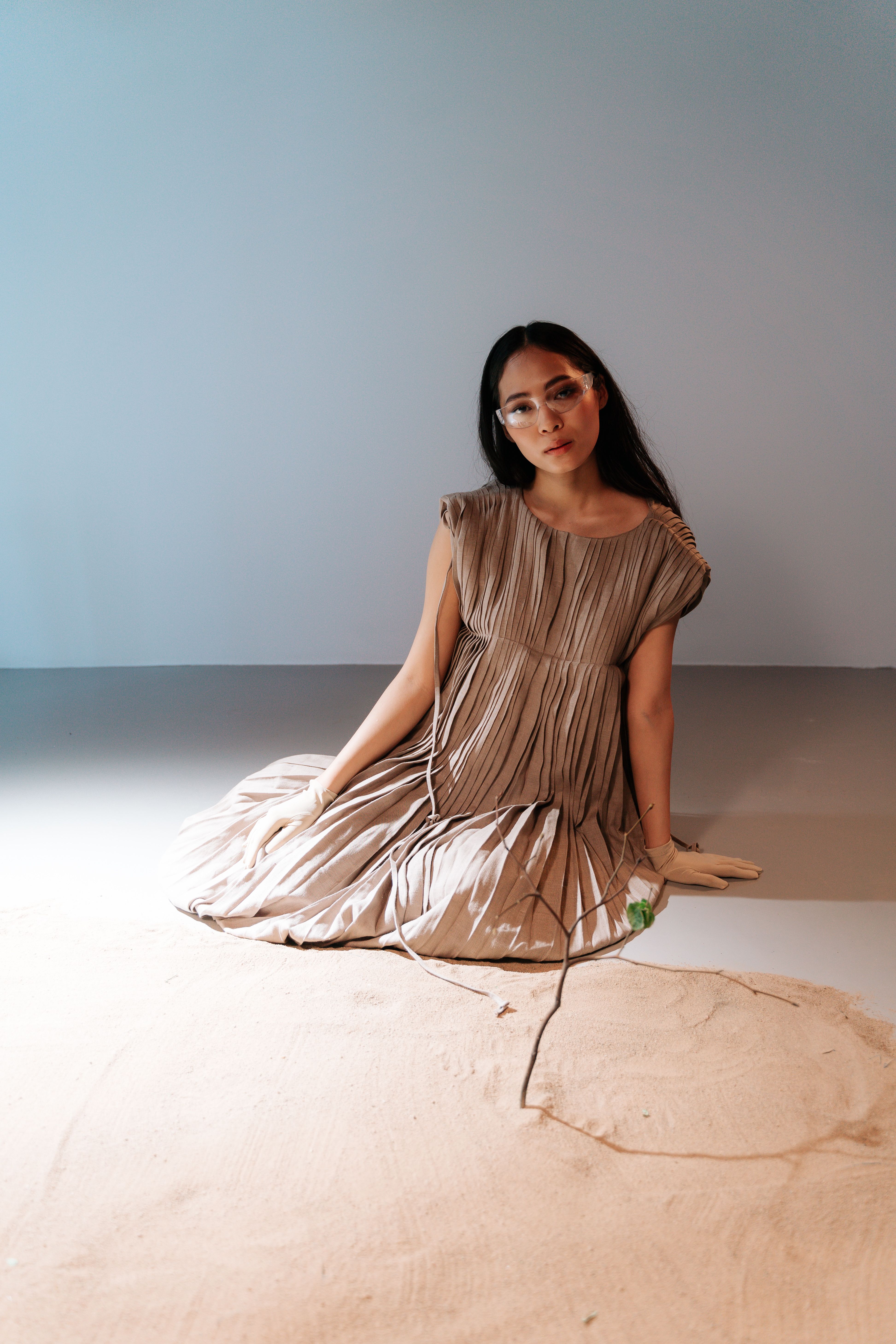 A Woman in Brown Dress Sitting on the Floor Near the Sand · Free Stock