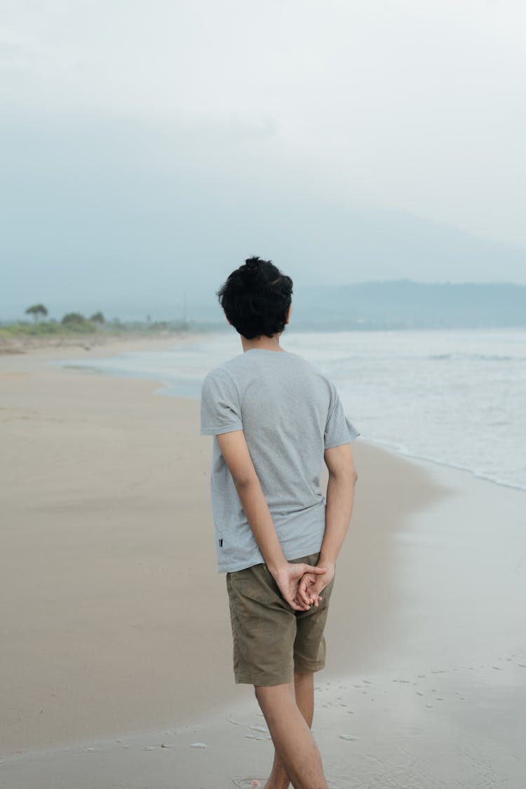 Man In Gray Shirt And Brown Shorts Standing On Seashore