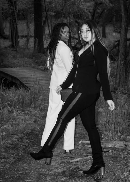 Woman in Black Suit Standing Beside Woman in White Suit