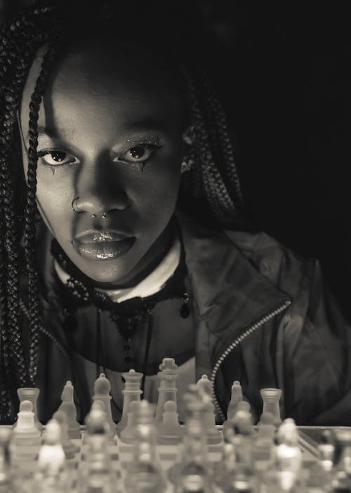 A Braided Hair Woman Near Chess Pieces