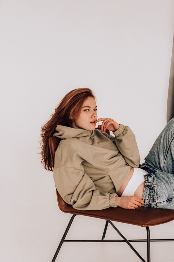 Woman wearing an umber knit hoodie with relaxed jeans