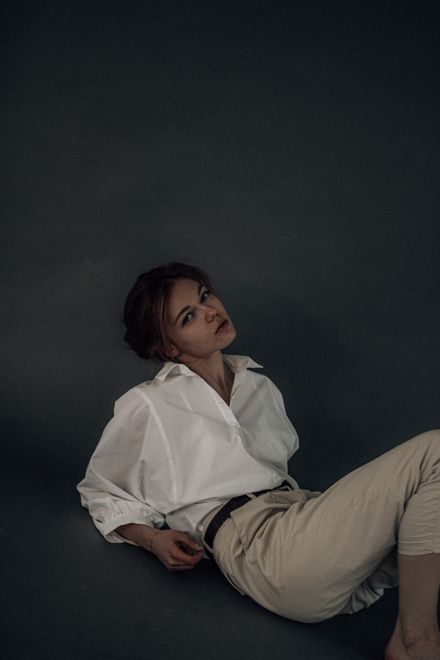 Studio portrait of a woman in an oversized blouse, photo by Карина Каржавина on Pexels