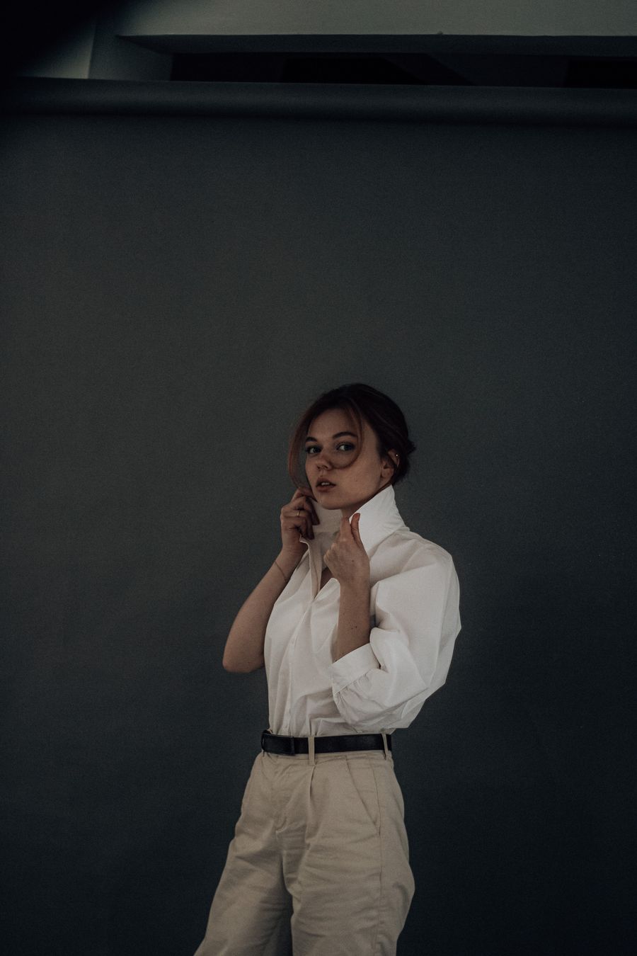 Editorial side portrait against a pale studio wall &mdash; photo by Карина Каржавина on Pexels