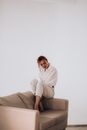 Tender woman sitting on arm of sofa