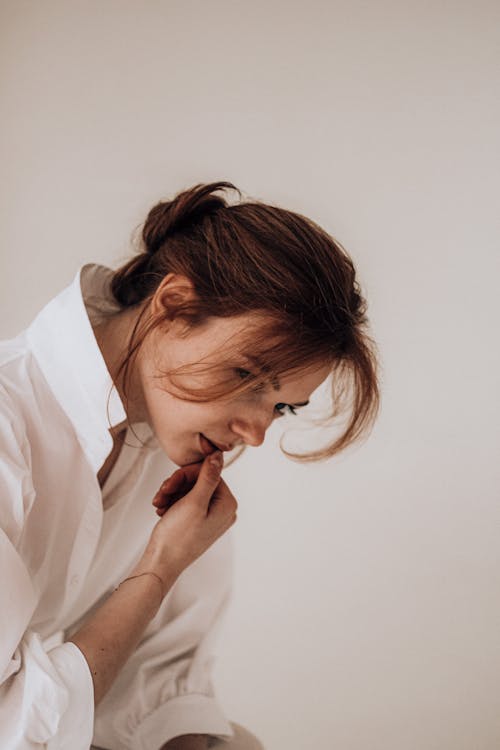 Thoughtful young female thinking in light room