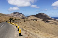 蔚蓝的天空下，一条蜿蜒的道路穿过葡萄牙马德拉干燥的山区