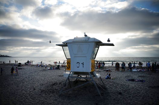 黄昏时分，圣地亚哥海滩充满活力，人群和救生员塔点缀其间