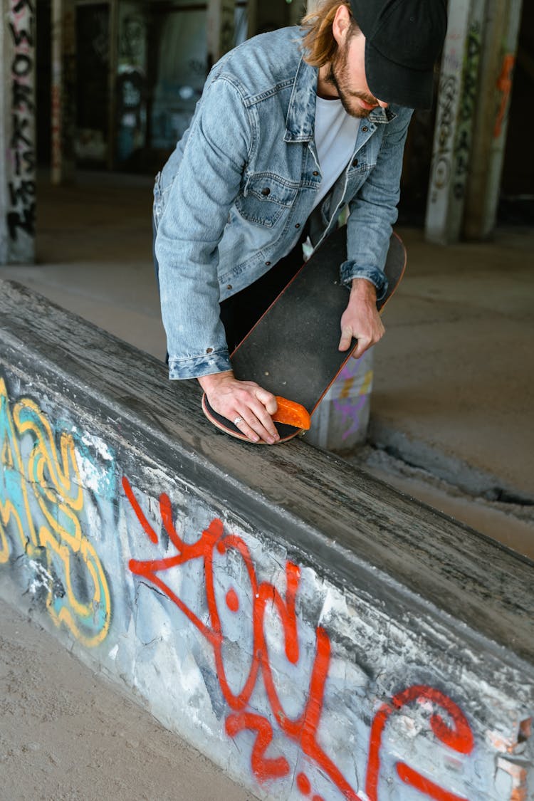 A Skater Waxing His Skateboard