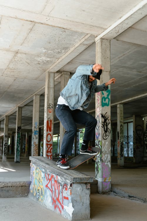 Free Man in Denim Jacket Doing Skateboard Stunts Stock Photo