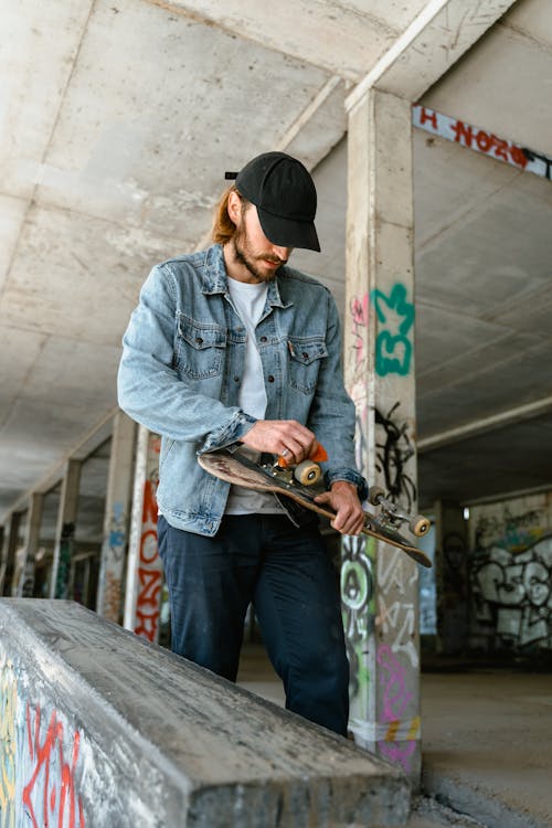 Free Man in Blue Denim Jacket and Black Pants Holding A Skateboard Stock Photo