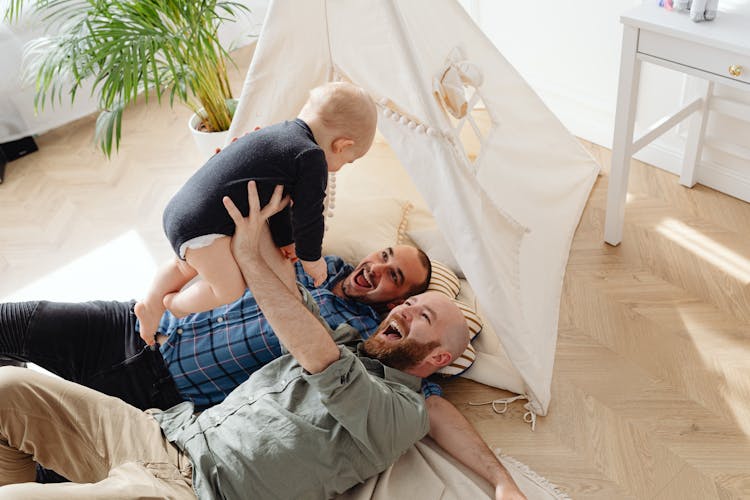 Two Men Playing With A Child