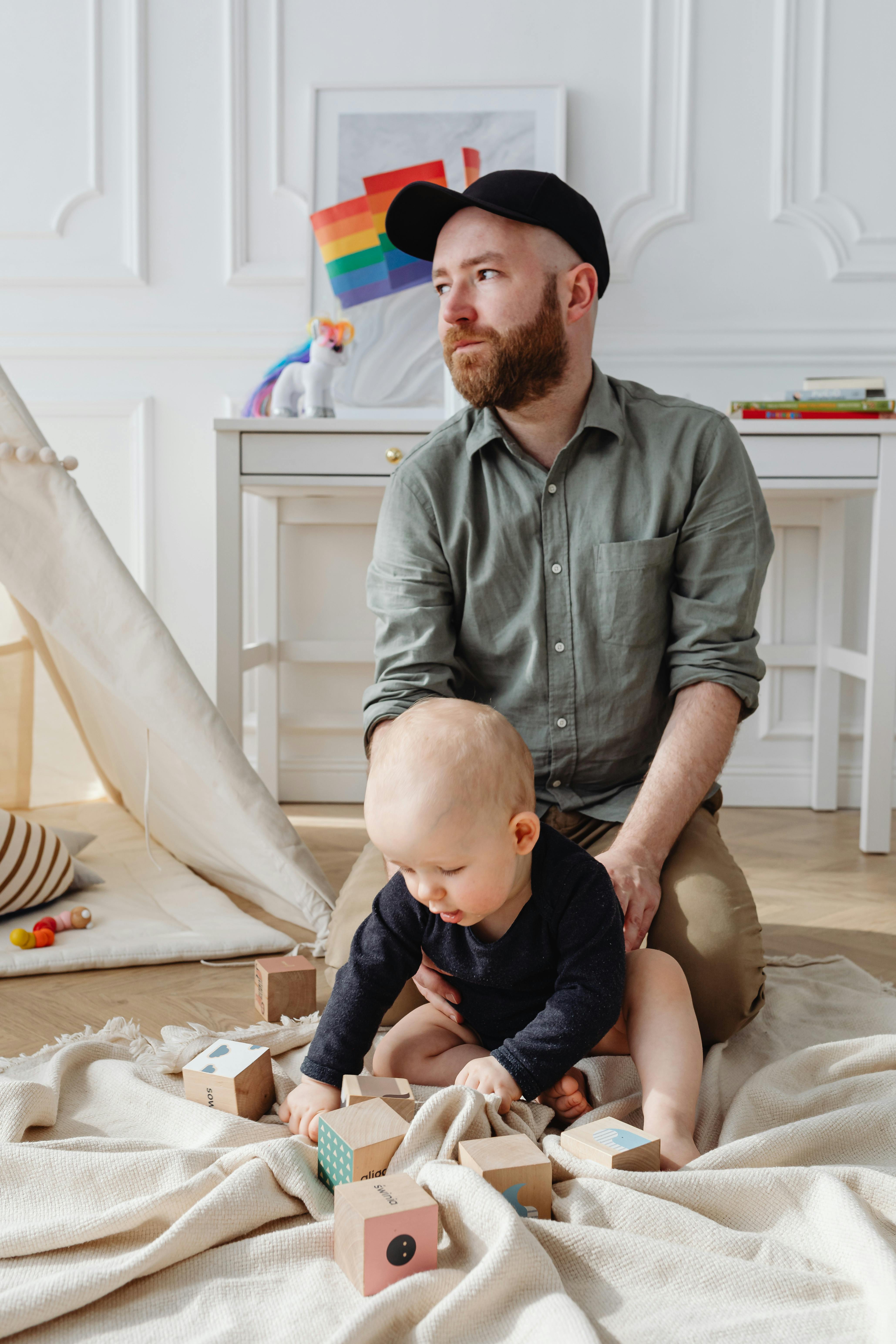 a bearded man with his baby in a living room