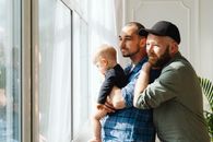 A Couple Looking Out the Window with Their Baby