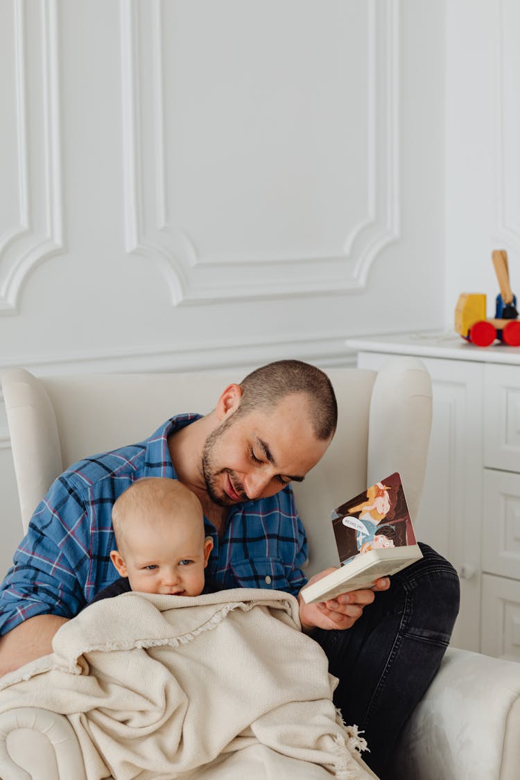 A Man Reading A Book To A Child