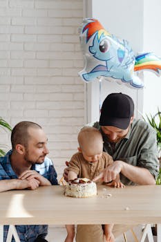 A loving LGBTQ family shares quality time during a child's birthday celebration with cake.