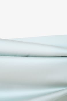 Gentle folds of soft light blue fabric showcasing elegant texture and smooth finish.