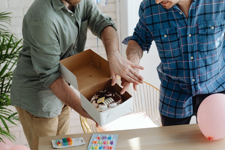 Man In Gray Polo Shirt Holding A Box With Birthday Cake Beside Another Man