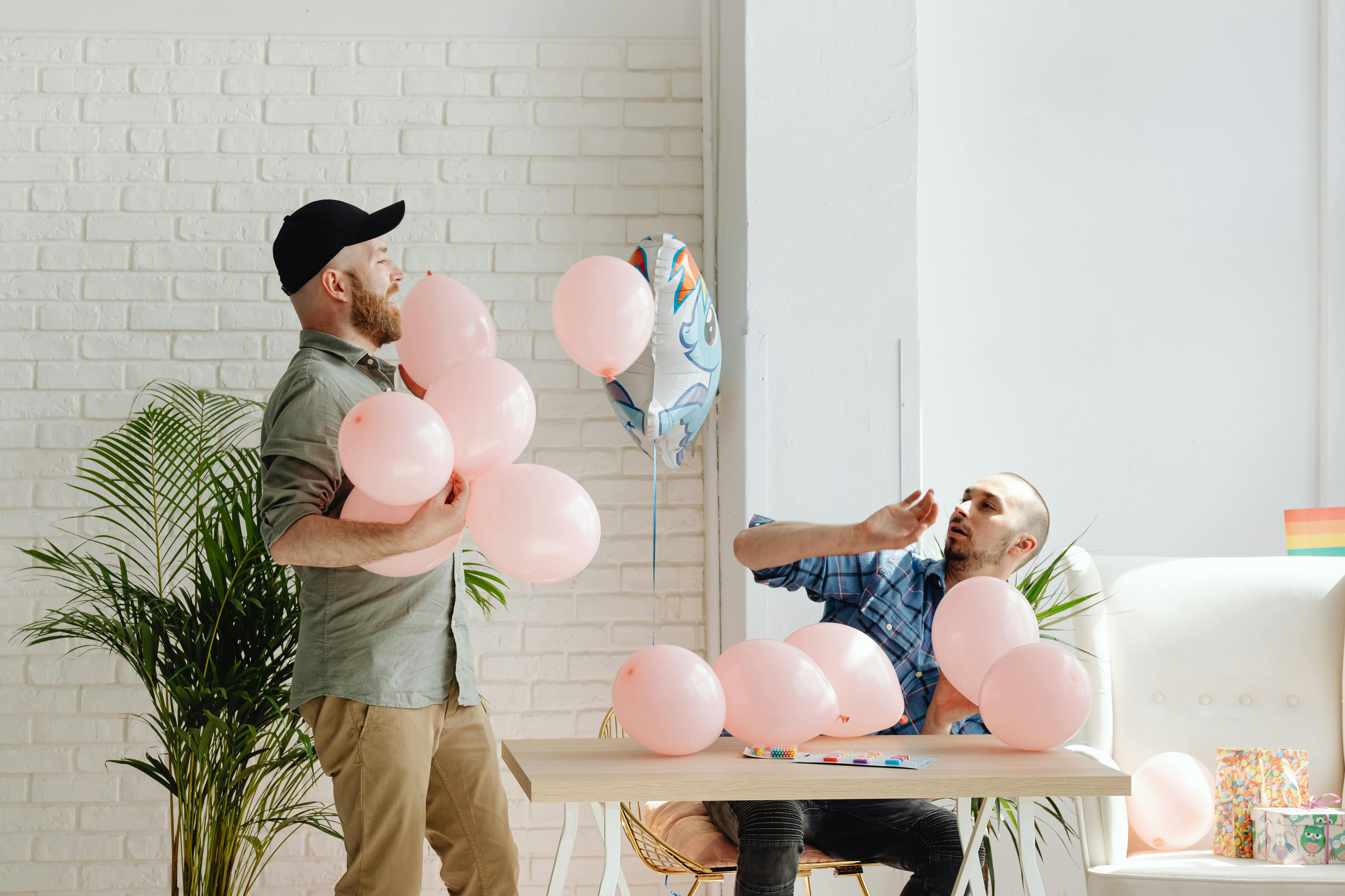 a same sex couple holding balloons