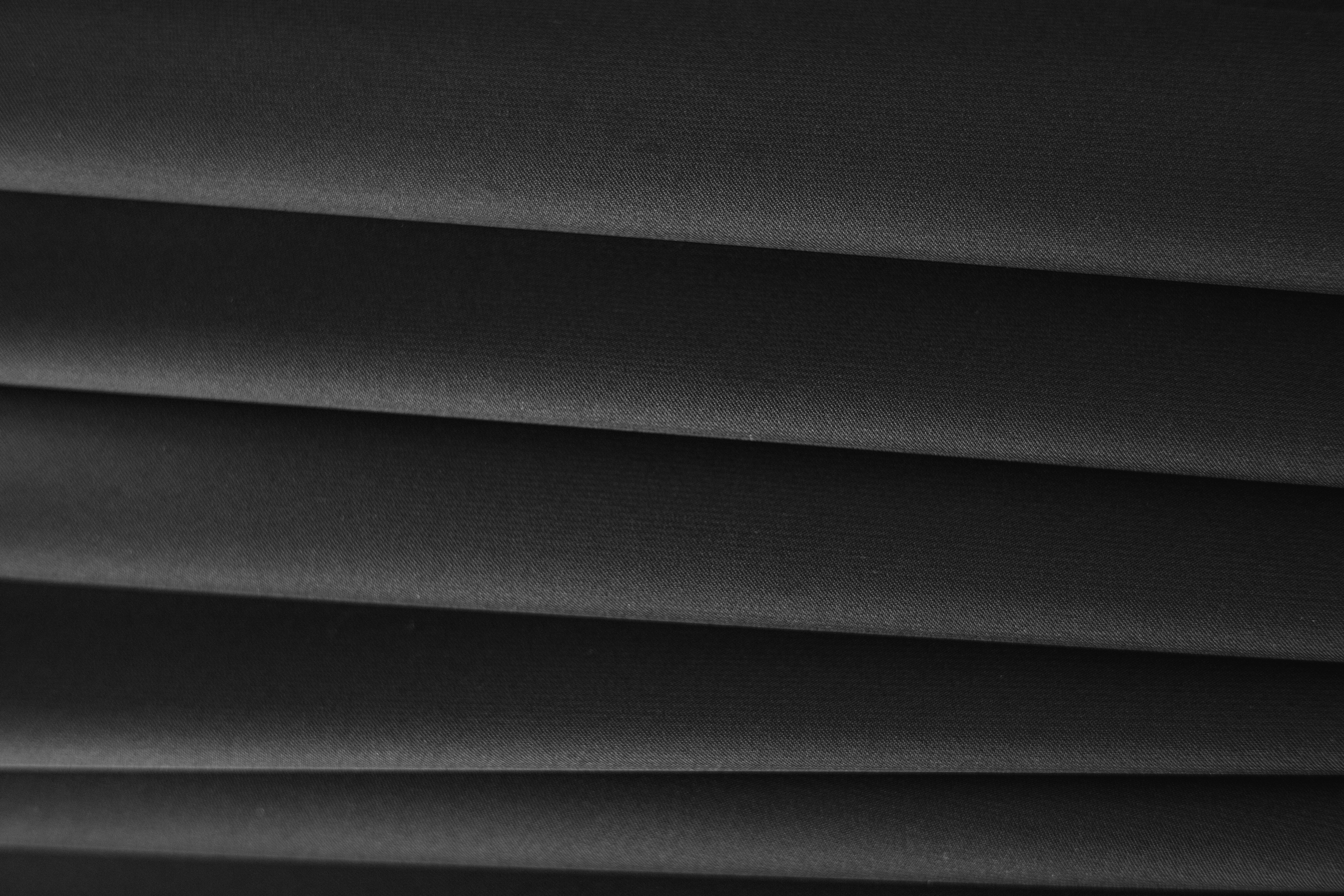 Close-up of sleek black textile showing texture and folds.