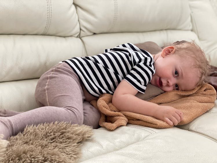 Cute Child Lying On Sofa At Home