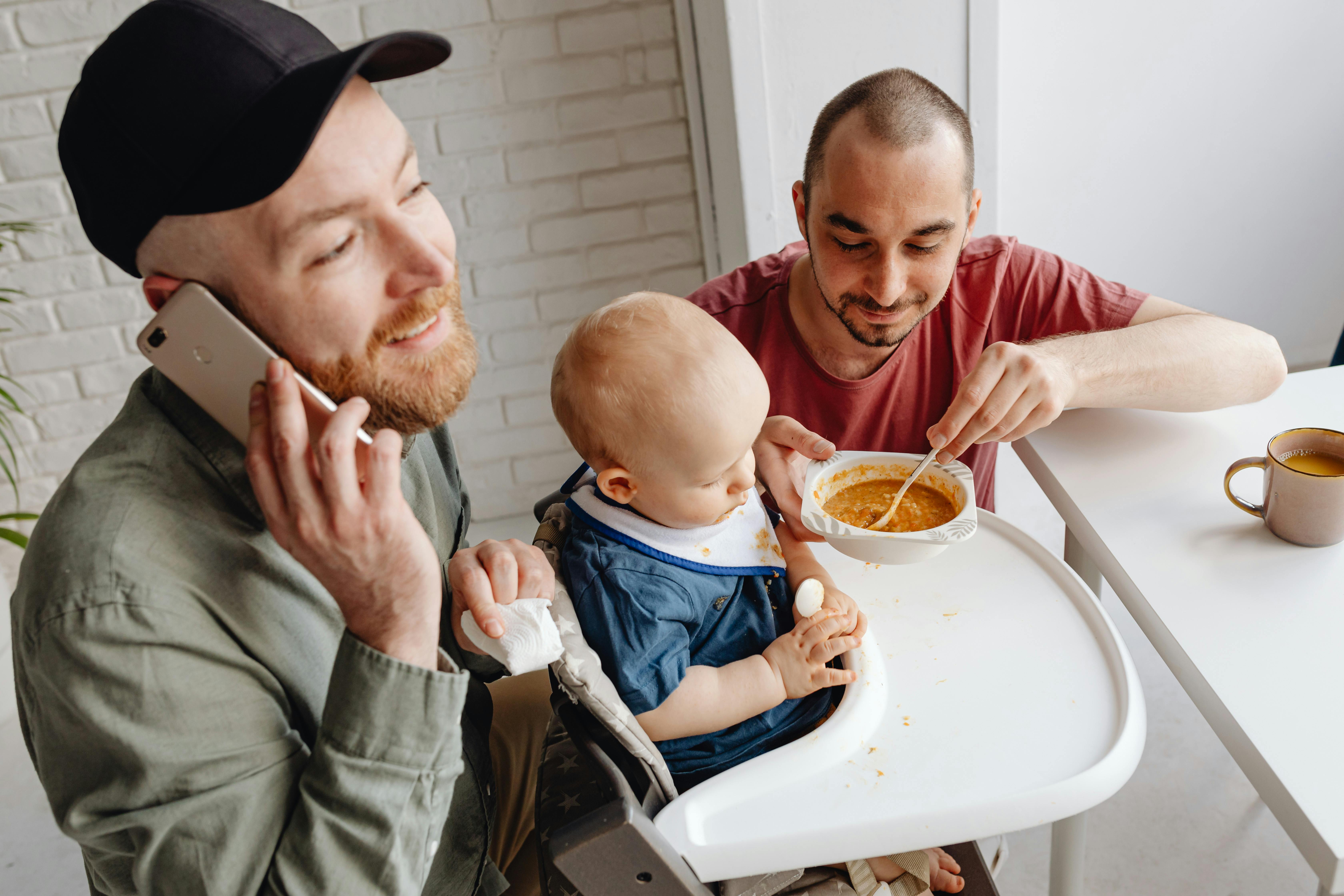 man in pink shirt holding baby food