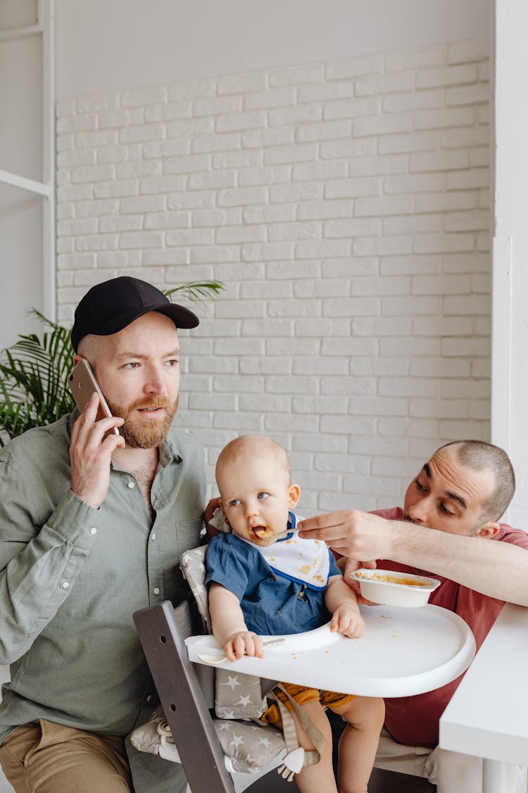 A Man Feeding A Boy