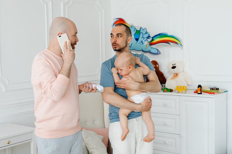 Two Men Feeling Worried Of Sick Baby