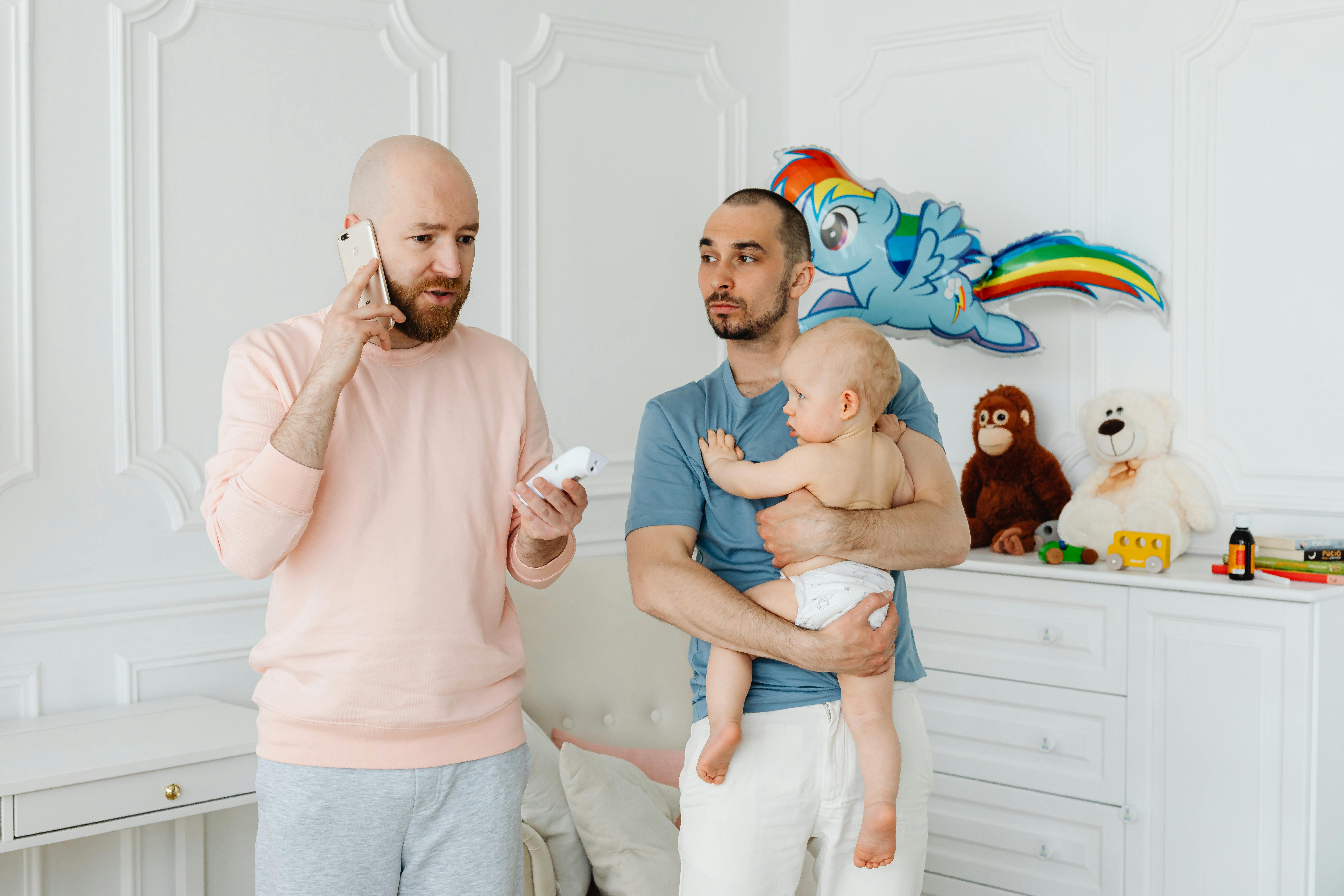 a man talking on the phone beside his partner carrying their son