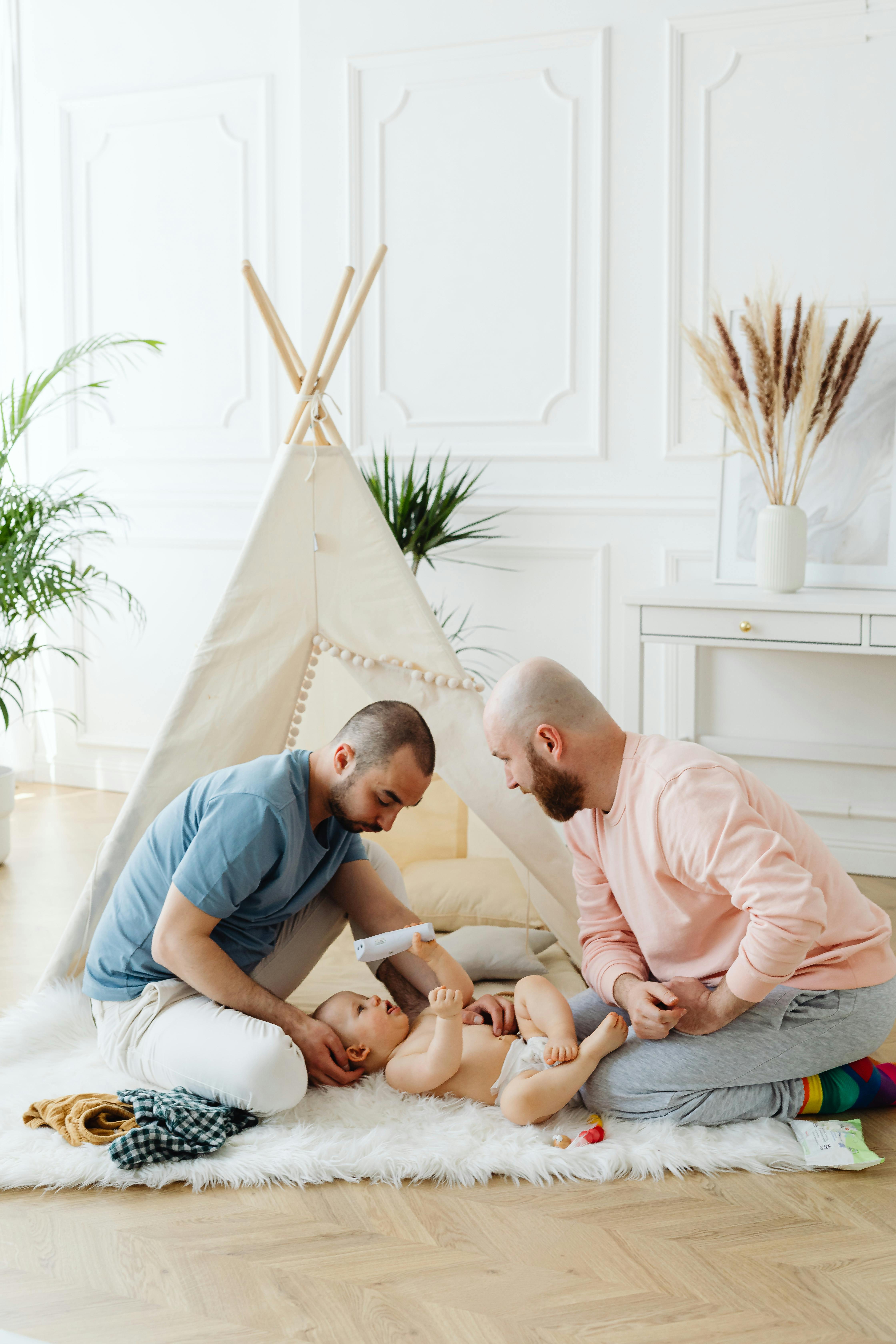 fathers playing with their baby on the carpet