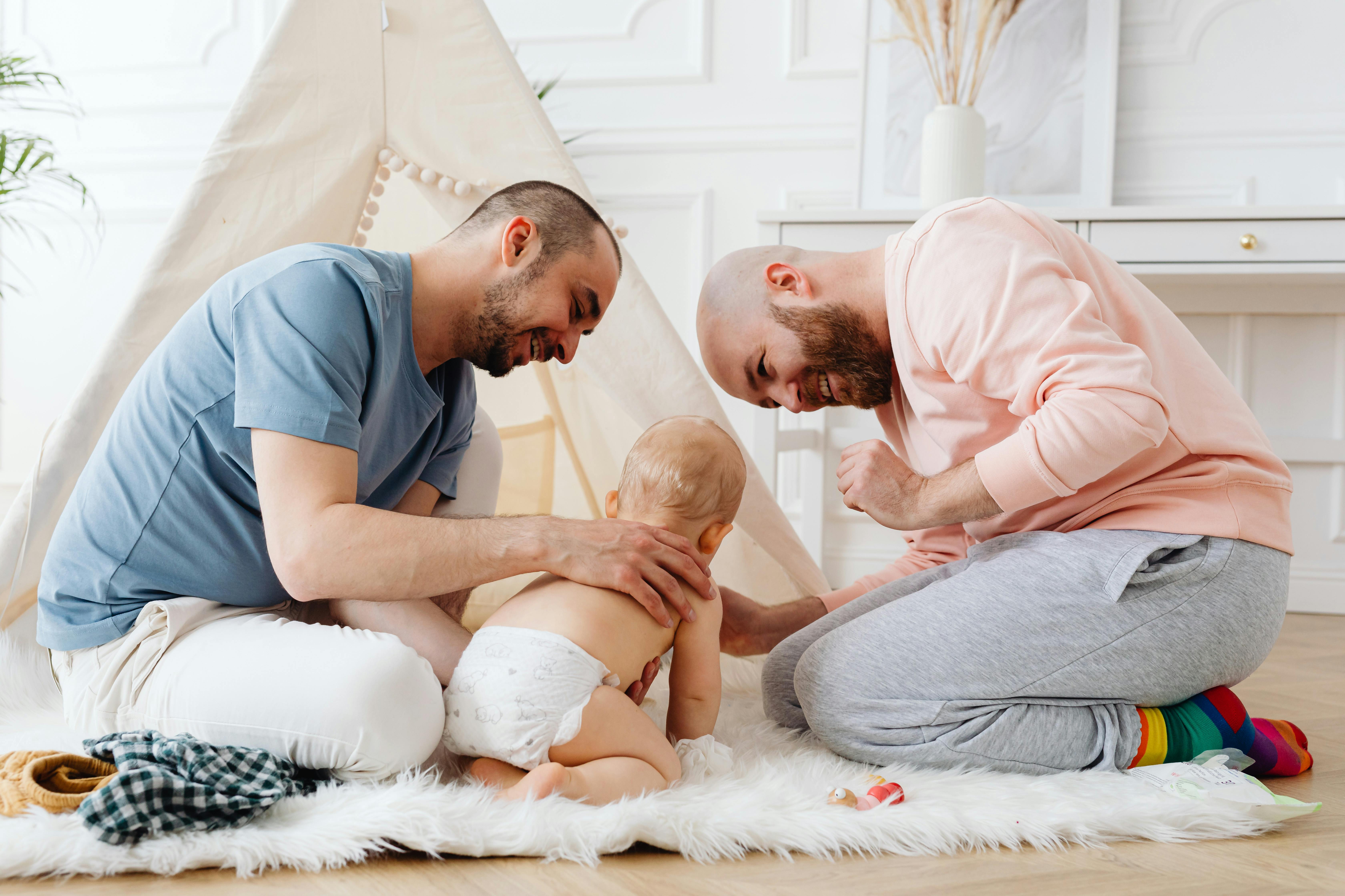 fathers playing with a baby crawling on the carpet