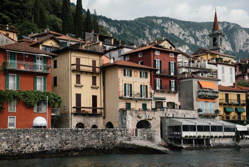 Free Scenic view of colorful houses by the lake with mountains in the background. Stock Photo